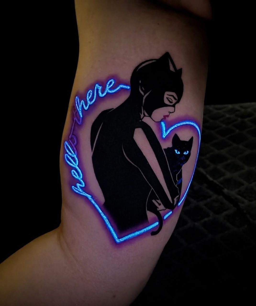 Catwoman tattoo glowing under UV blacklight