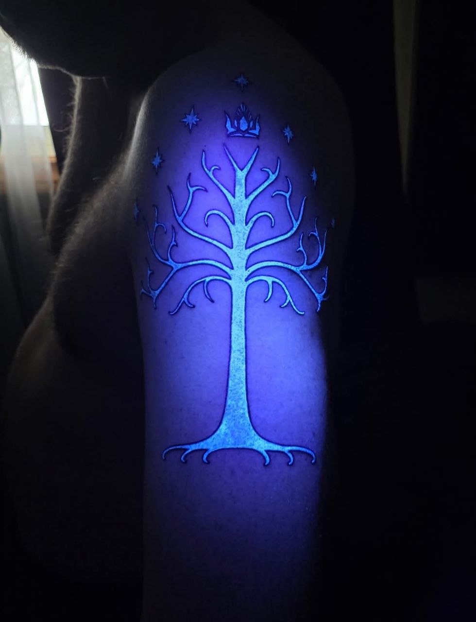 White Tree of Gondor tattoo glowing under UV blacklight